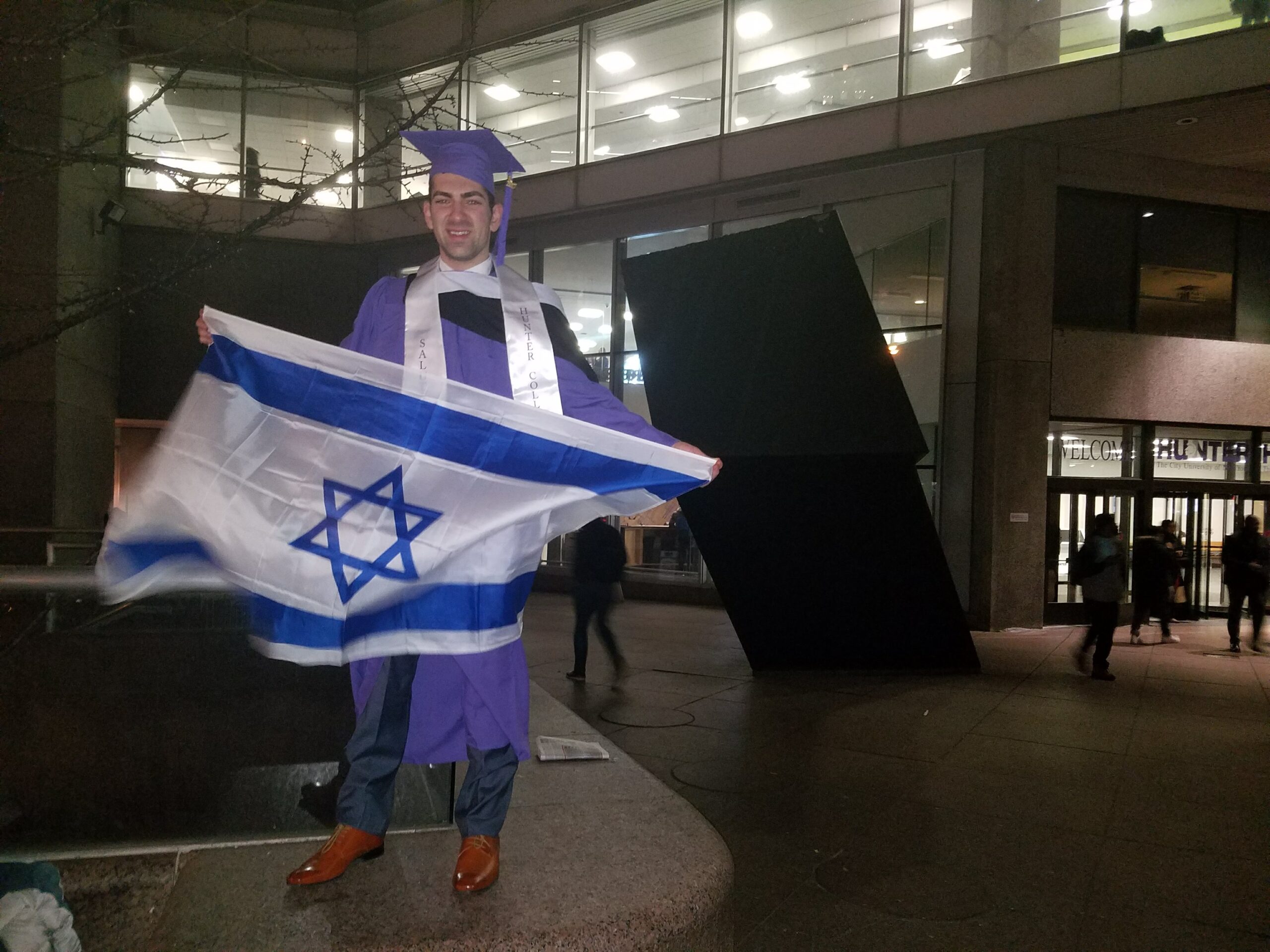 Charles waving his Israeli flag with pride at his college graduation, where the anti-Semitic rally took place.